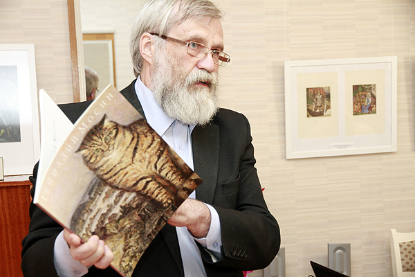 Алексей Мосин на выставке работ отца с альбомом в руках
